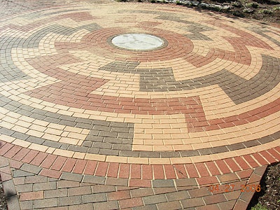 To fill the small spaces in between the circular-pattern pavers, use mortar or sand.