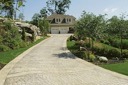 This new-construction house includes a stamped concrete drive and walkways, patios, irrigation, lighting, fencing and lush plantings.