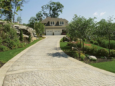 This new-construction house includes a stamped concrete drive and walkways, patios, irrigation, lighting, fencing and lush plantings.