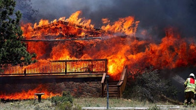 Fire consumed a home in Estes Park, Colorado, on June 23, 2012. This fire claimed as many as 21 structures. Photo: Darrell Spangler/AP