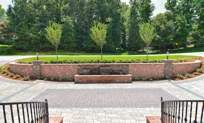 A hybrid driveway was designed with permeable sections to handle water issues on the property, and it includes a custom-built masonry wall using brick and natural Pennsylvania Veneer stone to match the home.