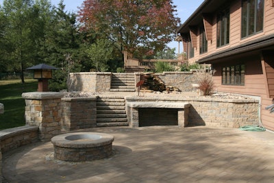 The design of this space grows from perfect circles. The materials are natural stone, Unilock II Campo pavers and Belgard retaining walls.