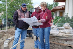 Terry Sims, right, talks with subcontractors about a project.