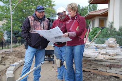 Terry Sims, right, talks with subcontractors about a project.