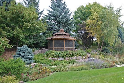 The Mustard Seed created a backyard retreat by installing stunning foliage, water features, pavers and a firepit.