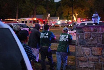 Other employees from the landscape company stand by and wait as recovery efforts are underway.