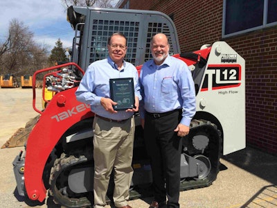 Clay Eubanks, president of Takeuchi, presents Dave Folcomer with the Top Volume Dealer of the Year award.