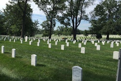 One of the many landscaping volunteers mows between the headstones at Arlington National Cemetery. Photo: David Rountree