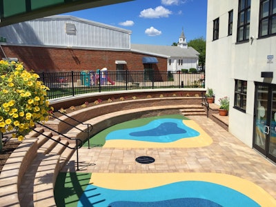 The 540-square-foot, semi-circular safety surface play area is constructed of poured-in-place Vitriturf rubber and features a blue, green and yellow pattern reminiscent of a lake with a beach and a meadow. Photo: Peter Wilk/Wilk Marketing Communications