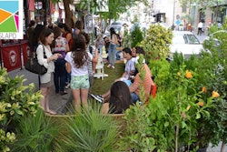 In this shot from a previous year’s Park(ing) Day observance, volunteers talk with passersby who stop to see the miniature park. Photo: American Society of Landscape Architects