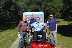 Walt Arnett is in the driver’s seat, with his Dad smiling alongside him, as Exmark representatives deliver his grand prize, the Exmark Lazer Z X-Series mower valued at more than $12,000. Photo: Exmark