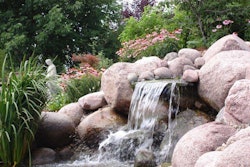 Watched over by a saint, this waterfall and garden features plantings both submerged in and surrounding the pond. RGMI does plenty of heavy lifting in its construction, installation and snow-removal operations but also has opportunities, as in this job, to show off its eye for design. Photo: Reinhart Grounds Maintenance