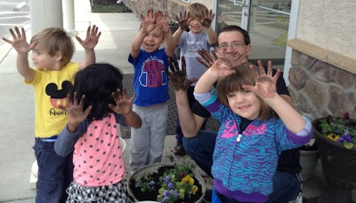 Brown is upstaged during a planting visit to an area day care center. Kirk’s Lawn Care participates in a variety of community service activities. Photo: Patty Vaughan