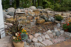 This waterfall, built into the woodland slope, adds a live element to the quiet oasis.