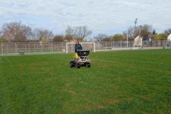 A Project EverGreen volunteer applies fertilizer recently to a field at the Cleveland recreation center. Photo: Project EverGreen