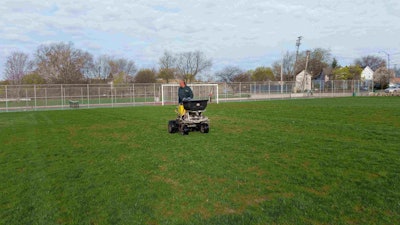 A Project EverGreen volunteer applies fertilizer recently to a field at the Cleveland recreation center. Photo: Project EverGreen