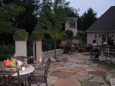 Landscape Solutions used flagstone for this outdoor living area, which is enclosed with knee walls and columns.