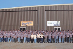 Loftness Specialized Equipment employees pose outside the company’s plant in Hector, Minnesota.