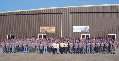 Loftness Specialized Equipment employees pose outside the company’s plant in Hector, Minnesota.
