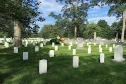 A landscaper spreads lime between the headstones at Arlington National Cemetery at last year’s Renewal and Remembrance. File photo