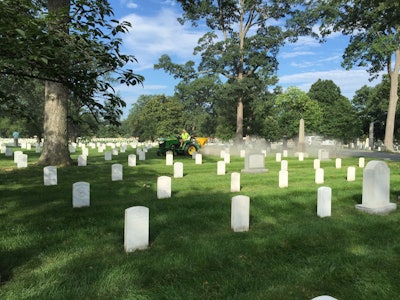 A landscaper spreads lime between the headstones at Arlington National Cemetery at last year’s Renewal and Remembrance. File photo