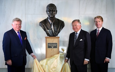 From left, the founder’s sons Mark Bamford and JCB Chairman Anthony Bamford, along with grandson Jo Bamford, the company’s group managing director of global accounts, unveil the new bust of Joseph Cyril Bamford, founder of JCB. Photo: JCB