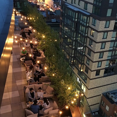 With nearby buildings rising well above this terrace, trees not only contribute to the pleasant surroundings but also function as a screen, providing a degree of privacy to the people meeting there. Strings of lights above the terrace compensate for the light blocked out by the trees. Photo: Blondie’s Treehouse