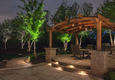 This landscape lighting project by McKay Landscape Lighting features uplighting on trees, lighting for steps and accent lights in the pergola. Photo: McKay Landscape Lighting