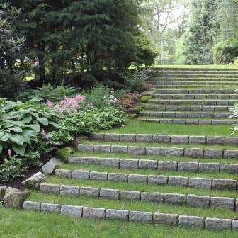 Curving grass steps add an elegant accent to a sloping garden. Belgian Block act as the step risers. Design and installation by Jan Johnsen, Johnsen Landscapes & Pools.