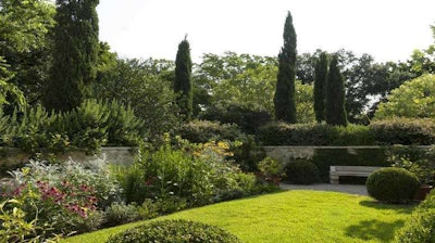 This low walled garden with dense trees and plants behind it feels like a secret retreat. Photo courtesy of Lambert Landscape Co., Dallas, Texas; LoveYourLandscape.org