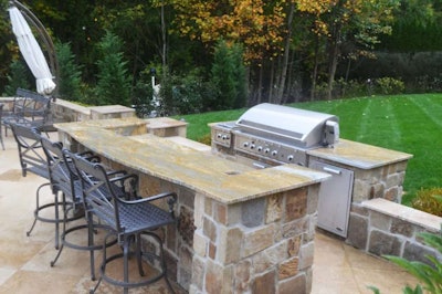 An outdoor kitchen built of natural stone with granite countertops. Photo: Courtesy of RTK Design Group