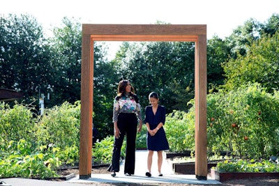 Michelle Obama stands with Tammy Nguyen, a student participating in the first lady’s “Let’s Move!” initiative, beneath a new arbor designed by UVA students for the White House Kitchen Garden. Photo: White House/Amanda Lucidon