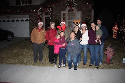 This military family was surprised by friends and family waiting to see their reaction to the Christmas lights. Photo: Signature Landscapes