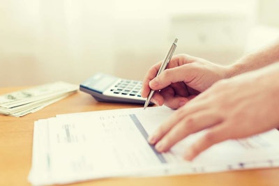 Person Sitting at Desk Paying Their Invoices