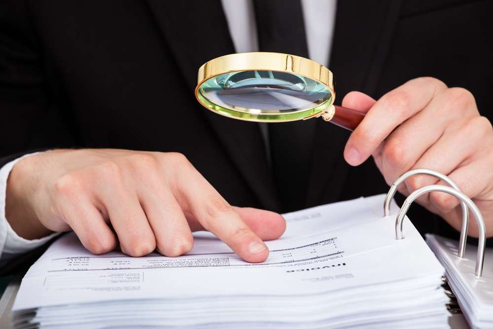 Business Man Reading Invoice With Magnifying Glass