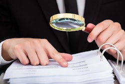 Business Man Reading Invoice With Magnifying Glass