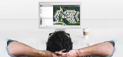 man relaxing with a coffee in front of desktop computer