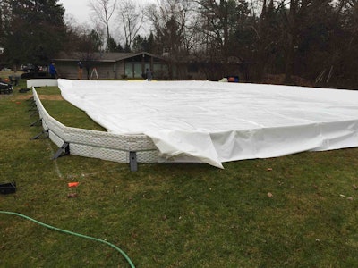 Crews spread the rink’s liner before filling it with water. Photo: Berns Landscaping Services, Inc.