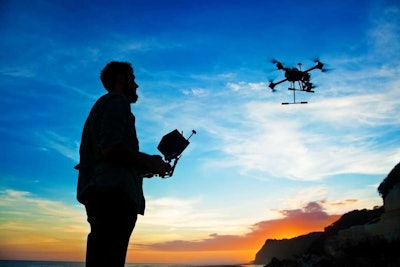 man flying drone at sunset