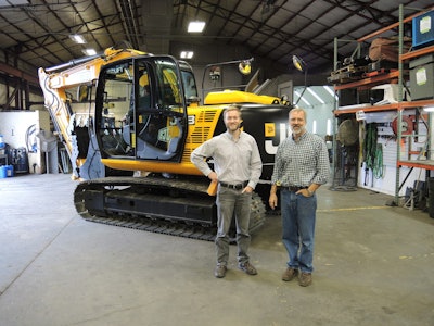 Owner of Norlift JCB, Jay Jarvis, stands with sales manager, Nate Jarvis, in front of their first sold unit. Photo: JCB