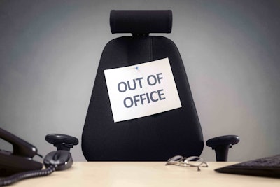 OUT OF OFFICE sign tacked to black chair