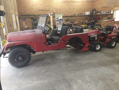 tractor used as a temporary rear axle for an older red jeep wrangler