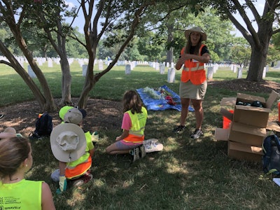 Racheal Kuperus instructs the children on how to construct their bouquets. Photo: Jill Odom