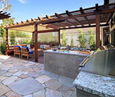 Gliksman created an outdoor kitchen that featured a covered dining area, a covered fire pit complete with built-in benches, an open patio, a swing and an entire garden. Photo: Urban Oasis Landscape Design