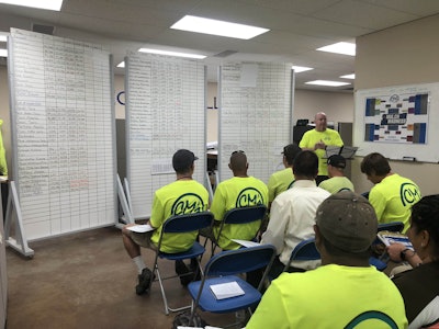 CM’s A Cut Above employees hold their weekly huddle to discuss company financials. Photo: Jill Odom