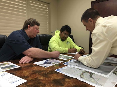 Chuck Monico (far right) discusses staging areas and work plans for a project with his employees. Photo: Jill Odom