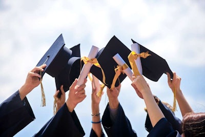 Graduates holding their caps and diplomas in the air