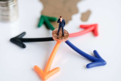 tiny man standing atop copper penny on tails side with multi colored arrows underneath penny