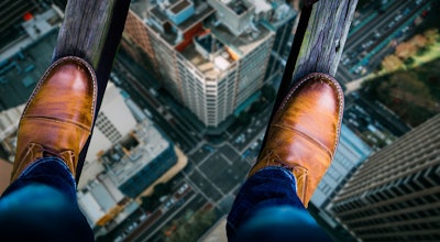 Construction worker looking down on a city steeet