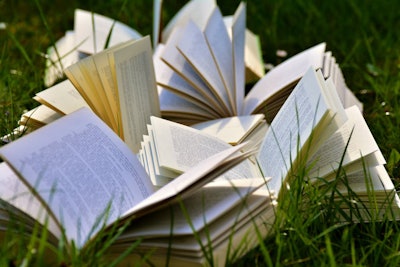 Books spread open outside on grass
